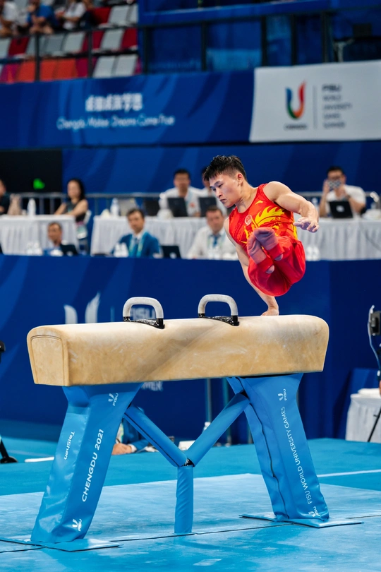 一个在体操比赛中表演平衡木的年轻人