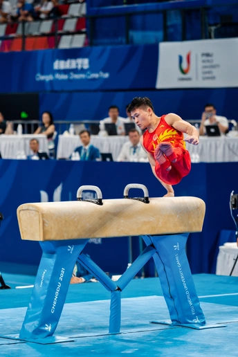 一个在体操比赛中表演平衡木的年轻人