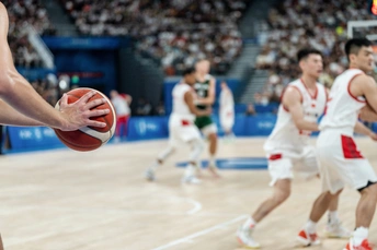 篮球场上有男子们在打篮球 观众席上有观众。