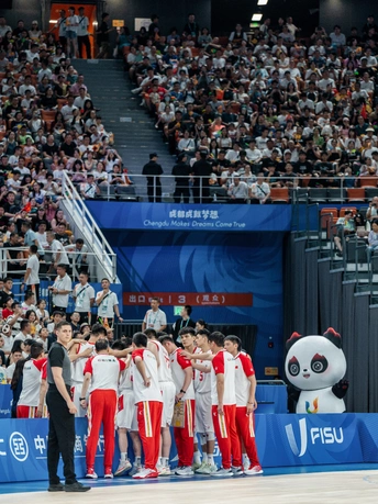 站在球场上的球员团队 前面有观众。