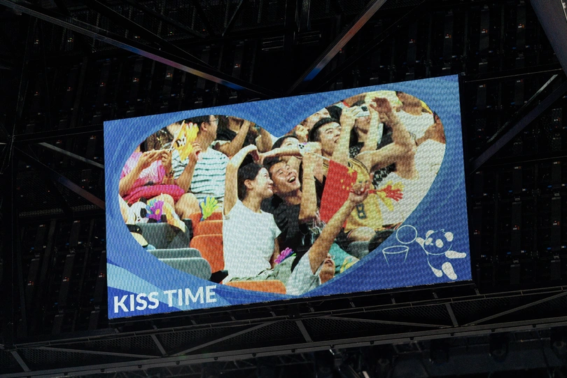 一个大屏幕 上面展示着人们在一场活动中的照片。