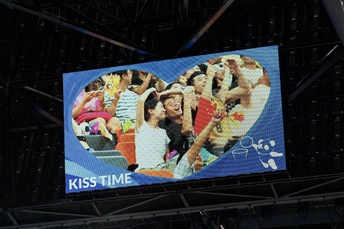 一个大屏幕 上面展示着人们在一场活动中的照片。