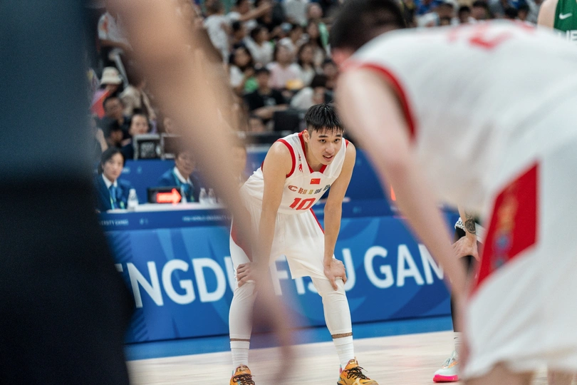 在中国和美国队的比赛中 一名篮球运动员在场上运球。