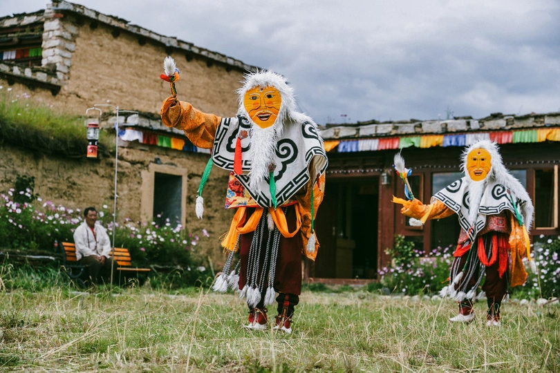 传统服装的村民们站在村子里的一所房子前面