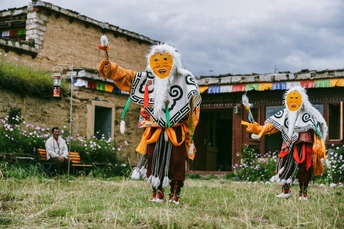 传统服装的村民们站在村子里的一所房子前面