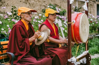 佛教僧侣在弹奏乐器并坐在长凳上
