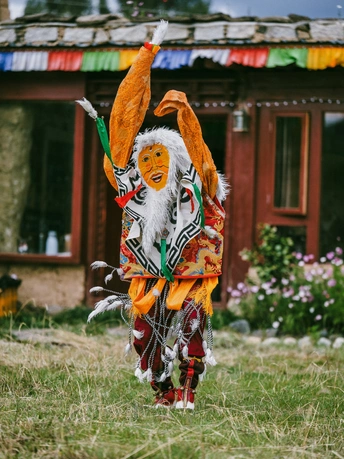 一个人穿着传统服装站在一所房子前面