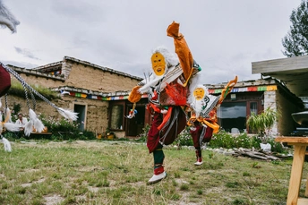 一个人穿着服装站在一所房子前面