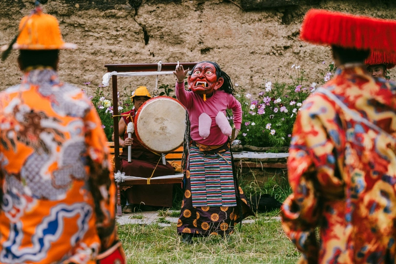 一个穿着小丑服装的人正在弹鼓并演奏音乐