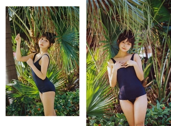 一位穿着黑色泳装的女士站在棕榈树森林中