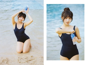 一位穿着泳装的女士在海滩上拿着一瓶水