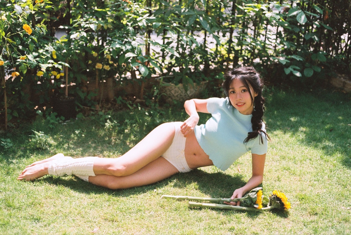 一位年轻女子在草地上俯身持滑板