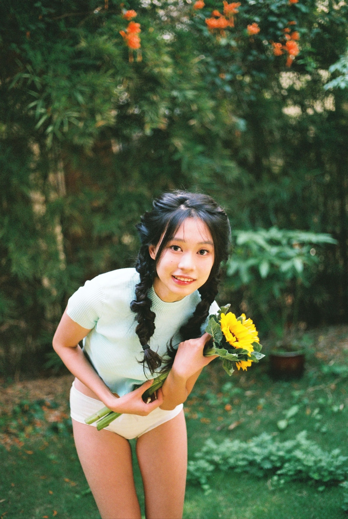 一位年轻女子在外边拿着黄色的花