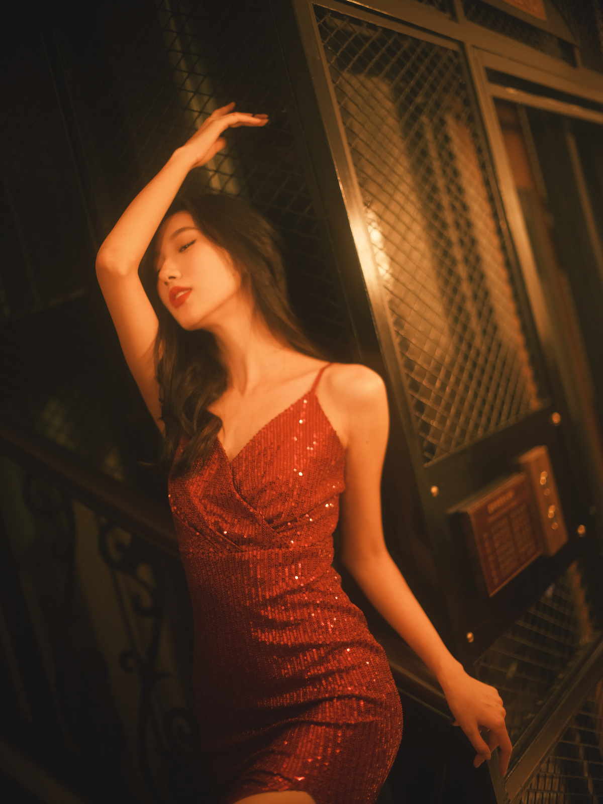 一个穿着红裙子的年轻女子站在电梯的楼梯上