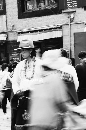 一张黑白照片 照片中一个戴着帽子的女人走在繁忙的街道上
