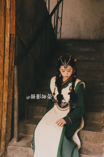 一位穿着传统服装的女性 身着绿色和白色连衣裙。