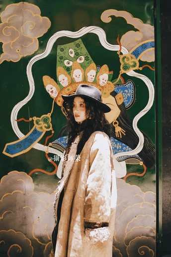 一位穿着外套和帽子站在壁画前的女人