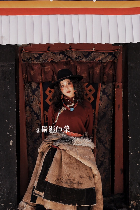 一位穿着传统服装的年轻女子站在门口