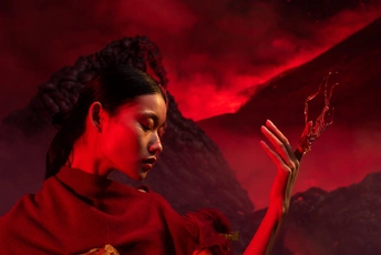 一个女人在一座着火的山前把手举在空中