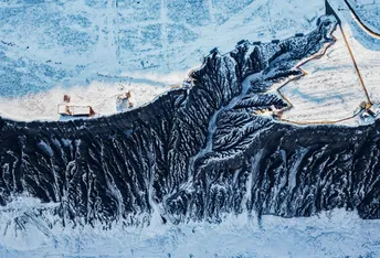 一幅人在雪中遛狗的画