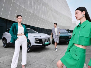 一位穿着绿色西装和白色裤子的女人正在街上走。