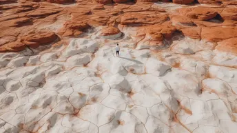 一位徒步旅行者在红色岩石结构的边缘站立。