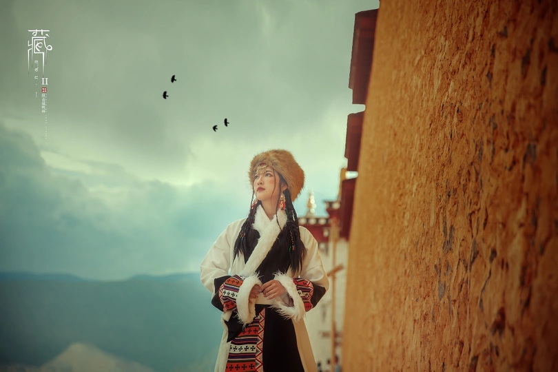 一位穿着传统服装的女性站在一面墙边