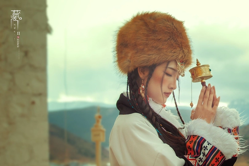 一个穿着中国传统服装的年轻女孩 戴着帽子 拿着铃铛。