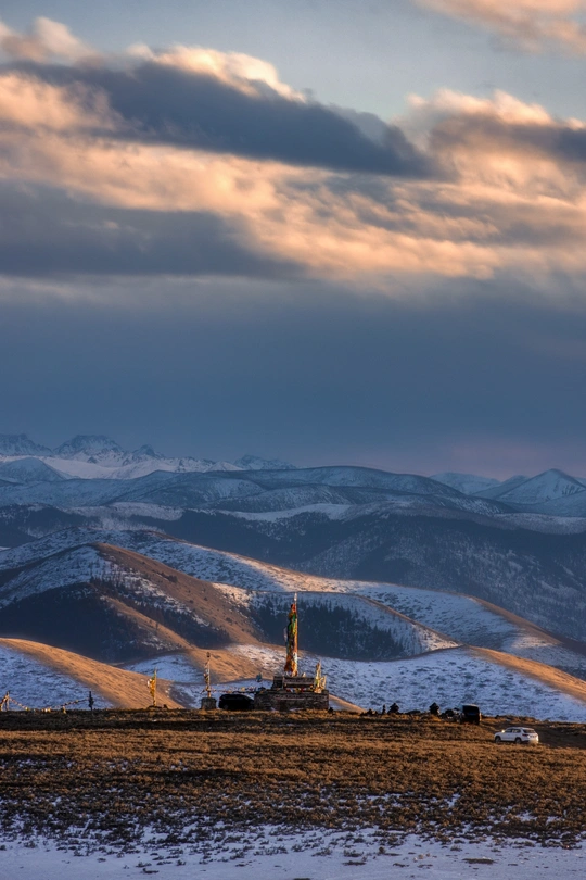 在日落时一个白雪皑皑的山坡上的教堂