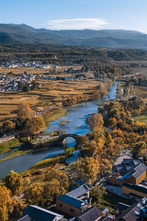 a river flowing through a valley with a small town