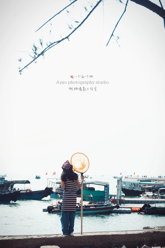 一个人站在水边拿着雨伞