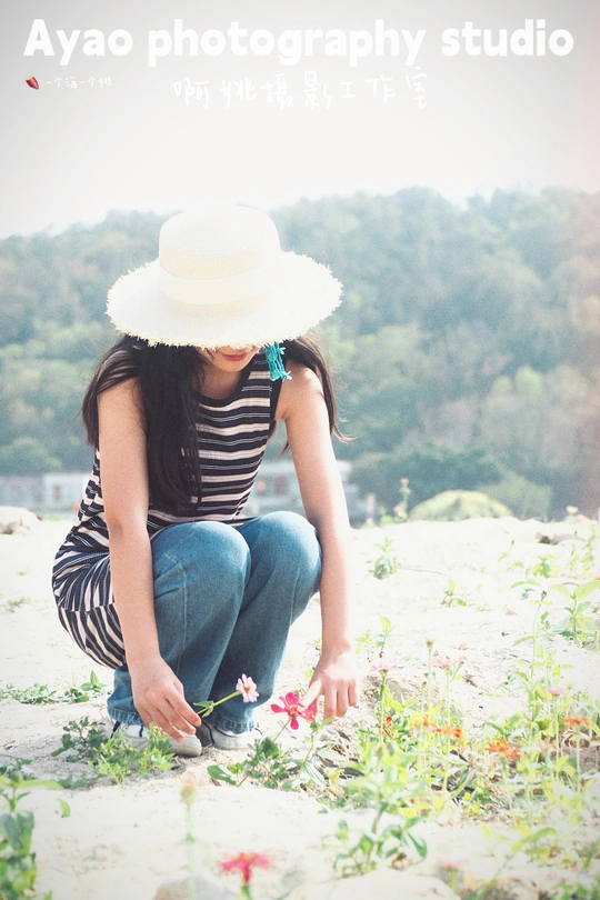 一个戴白帽子的年轻女子坐在沙滩上