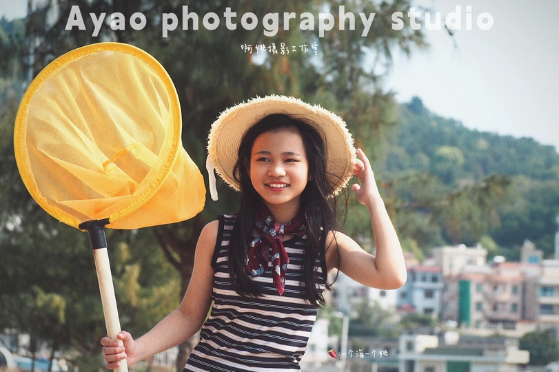 一位戴帽子的年轻女子手持黄色雨伞