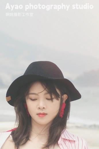 一位穿着粉红色衬衫和黑色帽子的年轻女子