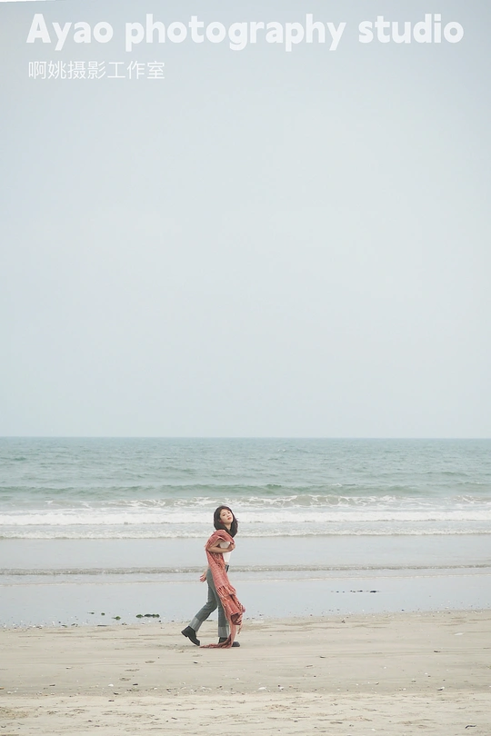 一个人和一个小女孩正在海滩上散步 靠近海洋。