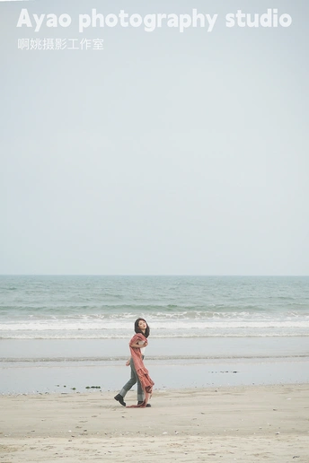 一个人和一个小女孩正在海滩上散步 靠近海洋。