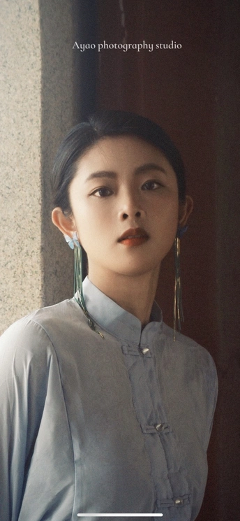 一个模特戴着耳环和戏剧性的唇妆。