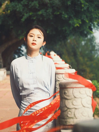 一位穿着连衣裙并系着红丝带的年轻女子