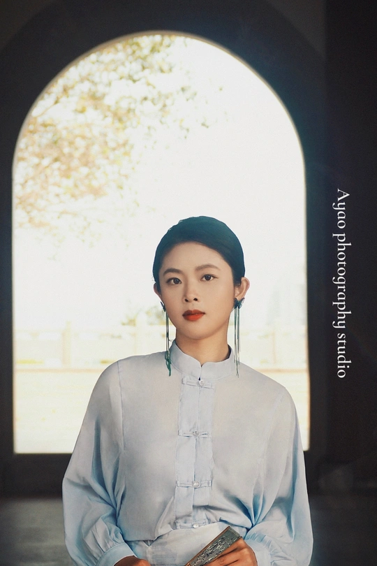 穿着传统服装的年轻女子抱着书