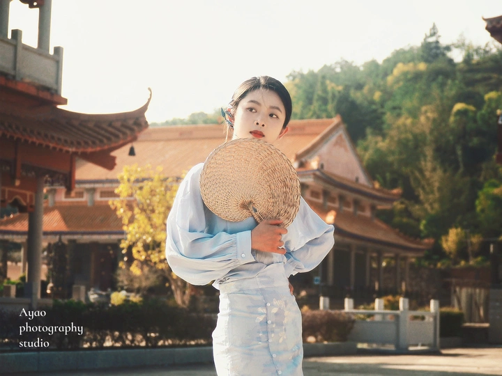 一个穿着传统服装的年轻男孩拿着草编帽子