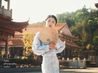 一个穿着传统服装的年轻男孩拿着草编帽子