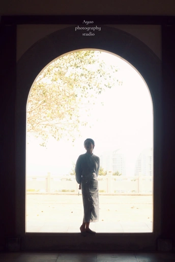 一个人站在建筑物的拱门处 光线透过窗户照射进来