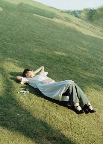 一个年轻女子躺在草地上 一个年轻男子躺在草地上。