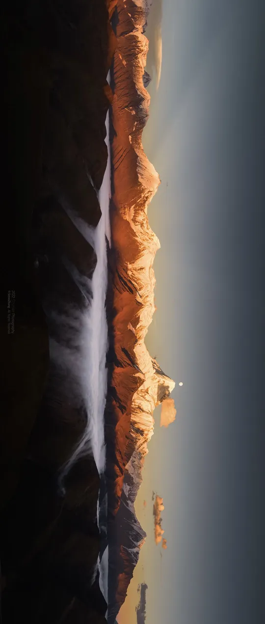 太阳照亮了峡谷中的山和水。