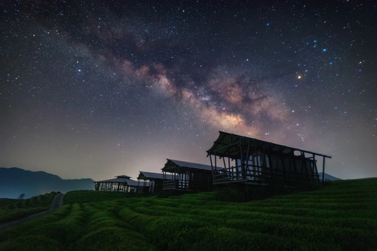 在星空下的一座山丘上的房子