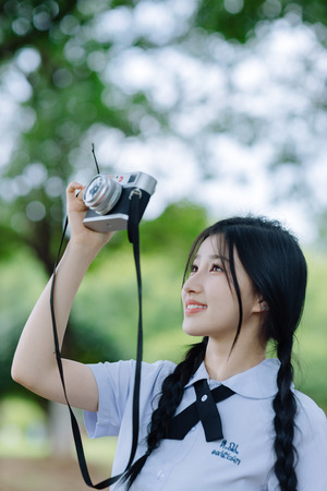 一位年轻女子手里拿着相机拍照