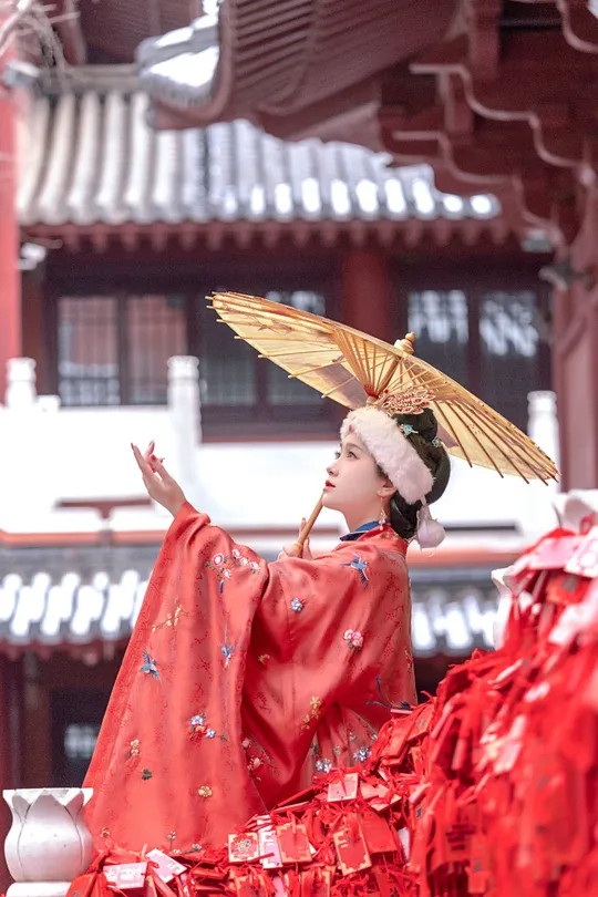 一位身着传统红色服装的女性在寺庙表演