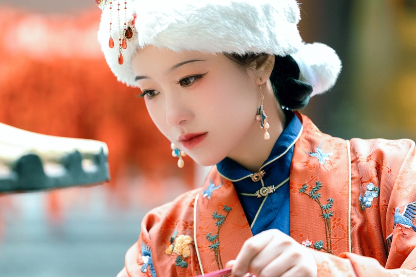 一位穿着传统服装的年轻女子戴着帽子