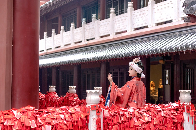 一位穿着红制服的男子站在一栋建筑前