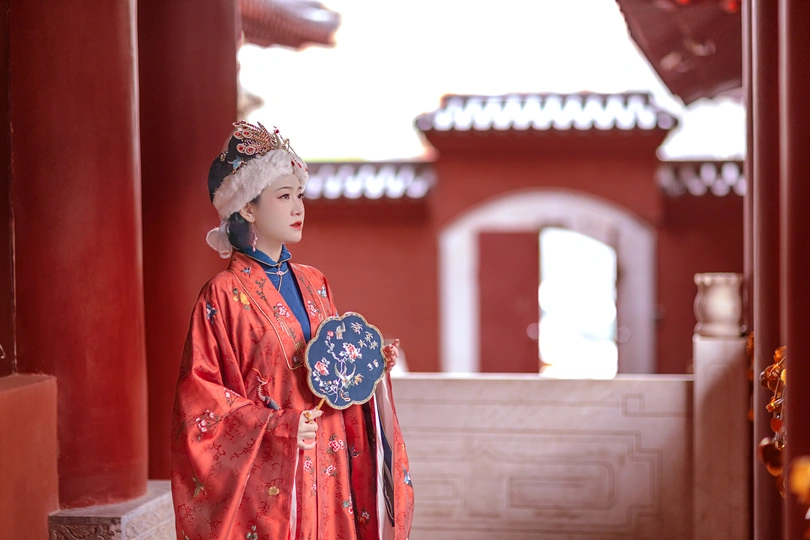 一尊穿着传统服装的女性雕像手里拿着一把雨伞。